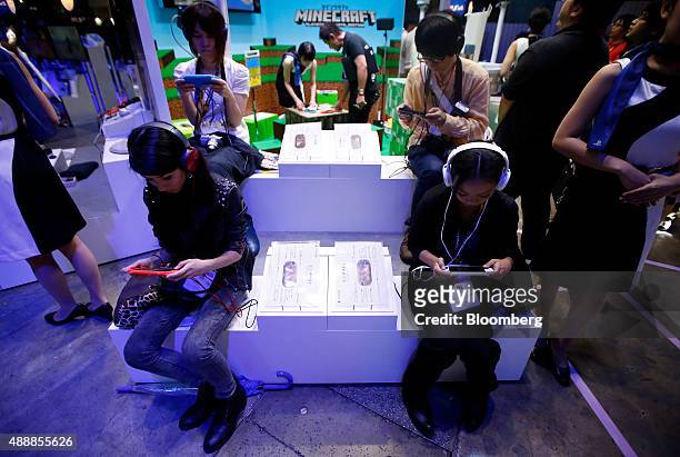 Attendees play video games on Sony Computer Entertainment Inc. PlayStation Vita portable video game players at the Tokyo Game Show 2015 at Makuhari...