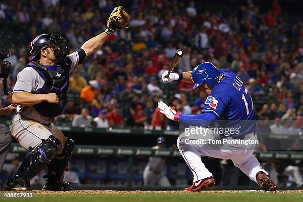 Michael McKenry of the Colorado Rockies pulls in a wild pitch as Shin-Soo Choo of the Texas Rangers reacts in the bottom of the seventh inning at...