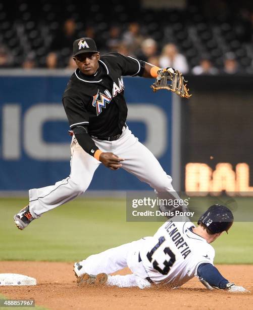 Adeiny Hechavarria of the Miami Marlins jumps over Chris Denorfia of the San Diego Padres as he turns a double play during the fifth inning of a...