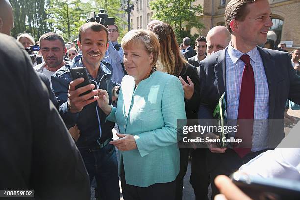 German Chancellor Angela Merkel pauses for a selfie with a migrant after she visited the AWO Refugium Askanierring shelter for migrants on September...