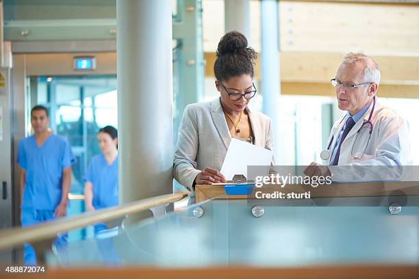 medical team discussing a case - sales executive stockfoto's en -beelden