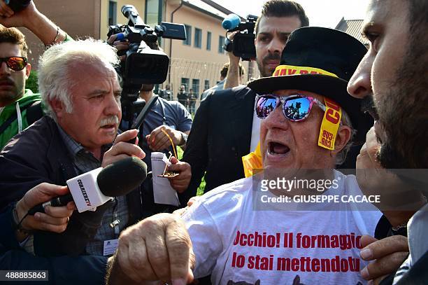 Man protests against Italian former Prime Minister Silvio Berlusconi near the Catholic hospice "Sacra Famiglia" in Cesano Boscone where Berlusconi...