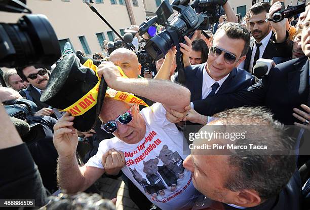 Protester against Silvio Berlusconi is stopped by security in front of the Fondazione Sacra Famiglia in Cesano Bosconeon May 9, 2014 in Milan, Italy....