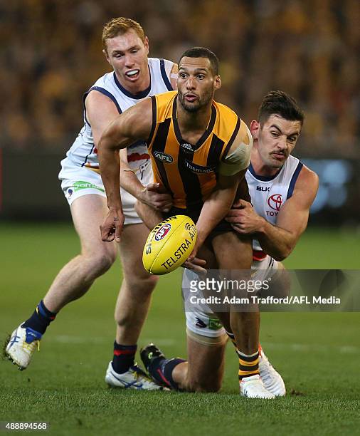 Josh Gibson of the Hawks is tackled by Tom Lynch and Taylor Walker of the Crows during the 2015 AFL Second Semi Final match between the Hawthorn...