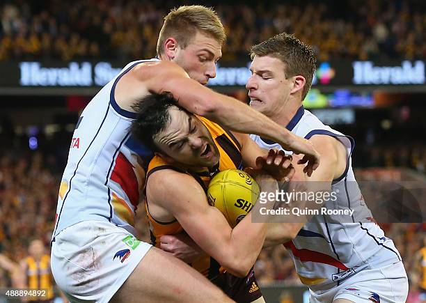 Jordan Lewis of the Hawks is tackled by Daniel Talia and Josh Jenkins of the Crows during the Second AFL Semi Final match between the Hawthorn Hawks...