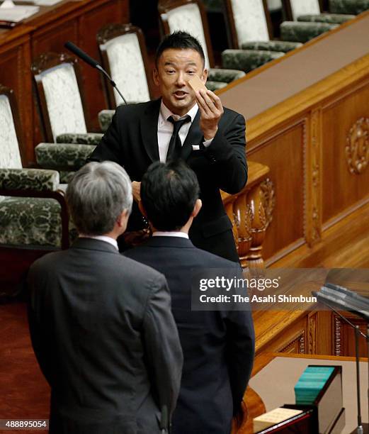 Upper house lawmaker Taro Yamamoto in mourning clothes votes in the sensure motion against Prime Minister Shinzo Abe during an Upper House plenary...