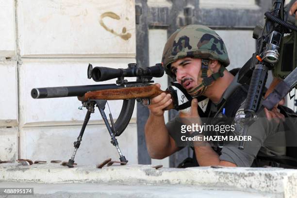 An Israeli border guard aims his sniper rifle during clashes with Palestinian protesters following an anti-Israeli protest after the weekly Friday...