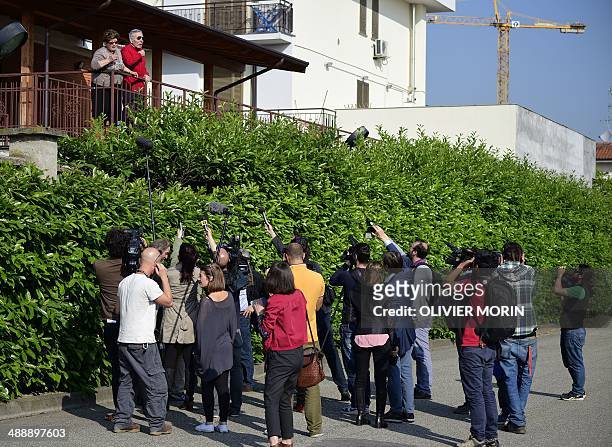 Journalists interview residents near the Catholic hospice "Sacra Famiglia" in Cesano Boscone before the arrival of Italian former Prime Minister...