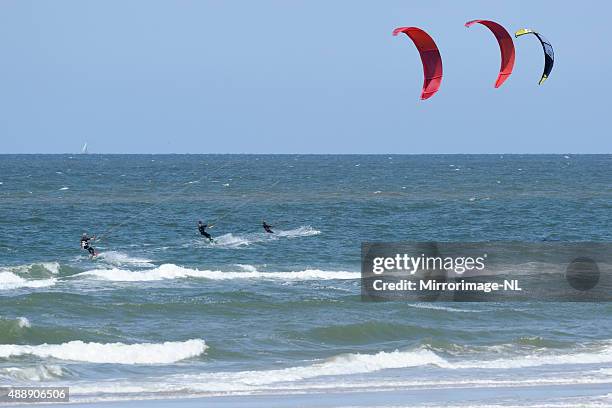 drei kitesurfers stellen im meer - kite surf stock-fotos und bilder