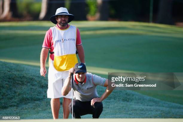 Martin Kaymer of Germany lines up a putt with his caddie Craig Connelly during the second round of THE PLAYERS Championship on The Stadium Course at...