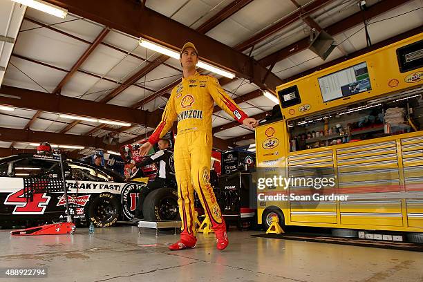 Joey Logano, driver of the Shell Pennzoil Ford, stands in the garage area during practice for the NASCAR Sprint Cup Series myAFibRisk.com 400 at...