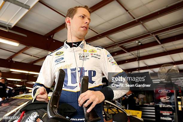 Brad Keselowski, driver of the Miller Lite Ford, stands in the garage area before practice for the NASCAR Sprint Cup Series myAFibRisk.com 400 at...