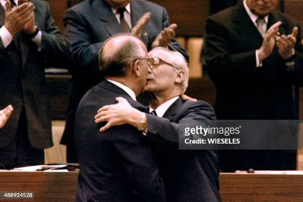 Soviet leader Mikhail Gorbachev embraces Erich Honecker, hardline communist and general secretary of the Communist Party as members of SED applaud...