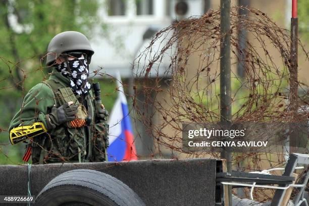 Masked armed man stands guard outside the regional state building seized by pro-Russia separatists in the eastern Ukrainian city of Donetsk on May 9,...