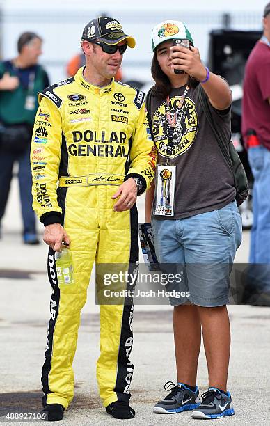 Matt Kenseth, driver of the Michael Wheeler, takes a photo with a fan prior to practice for the NASCAR Xfinity Series Furious 7 300 at Chicagoland...