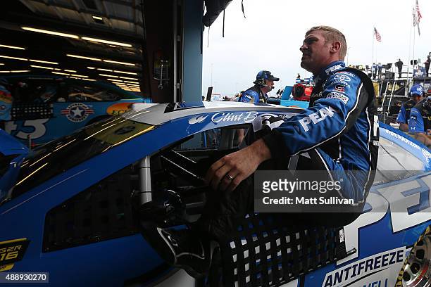 Clint Bowyer, driver of the PEAK Antifreeze & Coolant Toyota, gets in his car during practice for the NASCAR Sprint Cup Series myAFibRisk.com 400 at...