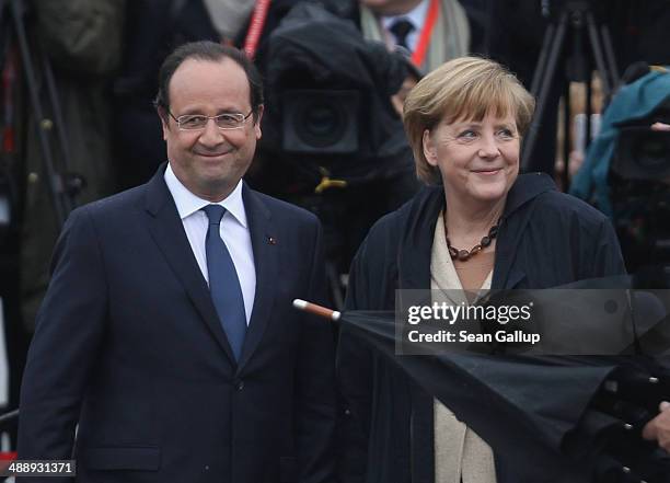 German Chancellor Angela Merkel and French President Francois Hollande arrive to board a boat to tour the nearby chalk cliffs on Ruegen Island on May...