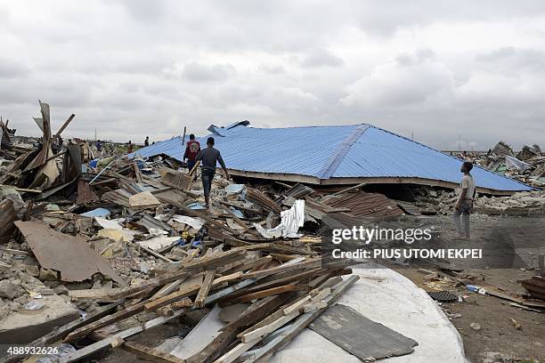 People walk past a demolished church following a court ruling which forcefully evicted residents of Badiya community at Ijora distict of Lagos, on...
