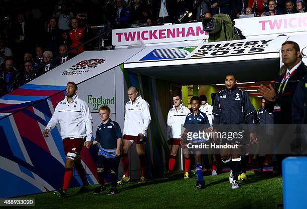In this handout photograph provided by World Rugby via Getty Images, Captains Chris Robshaw of England and Akapusi Qera of Fiji lead the teams out...