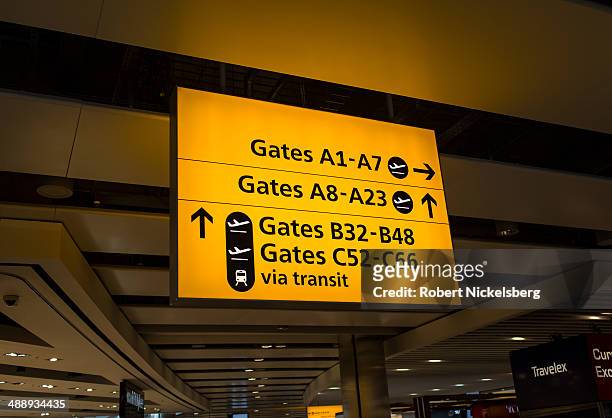 Airline passengers follow signs for their flight departures March 13, 2014 at London, England's Heathrow Airport.