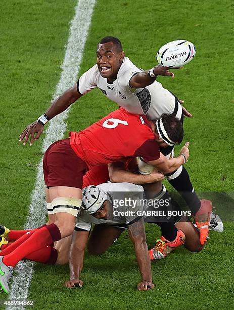Fiji's lock Leone Nakarawa tries to pass the ball as England's flanker Tom Wood tackles him during a Pool A match of the 2015 Rugby World Cup between...