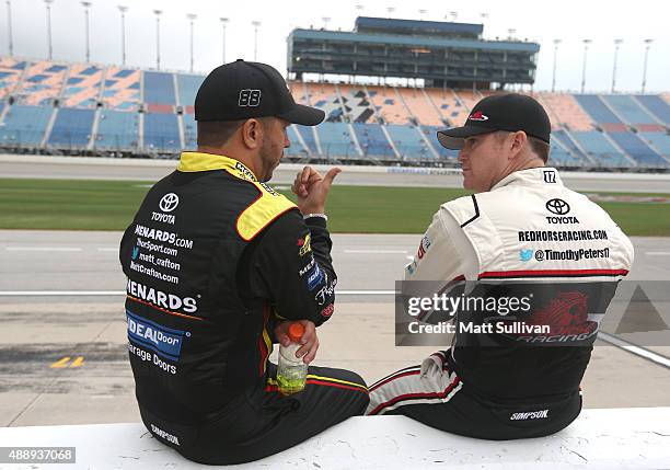 Matt Crafton, driver of the Slim Jim//Menards Toyota, talks to Timothy Peters, driver of the Red Horse Racing Toyota, on the grid during qualifying...
