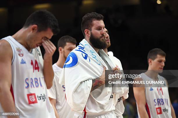 Serbia's power forward Zoran Erceg, Serbia's center Miroslav Raduljica and Serbia's point guard Nemanja Nedovic react after Serbia lost their...