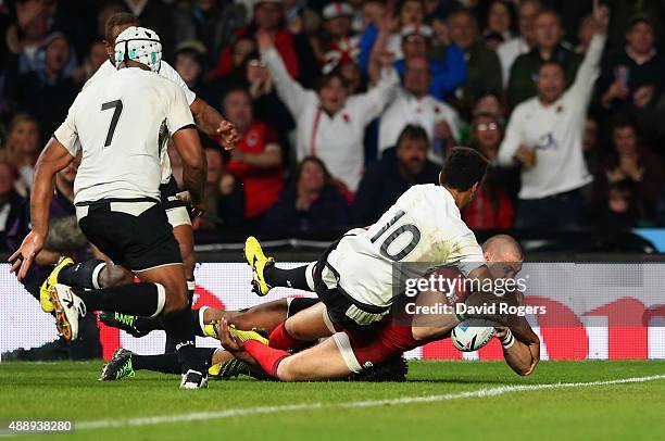 Ben Volavola of Fiji fails to stop Mike Brown of England scoring their third try during the 2015 Rugby World Cup Pool A match between England and...