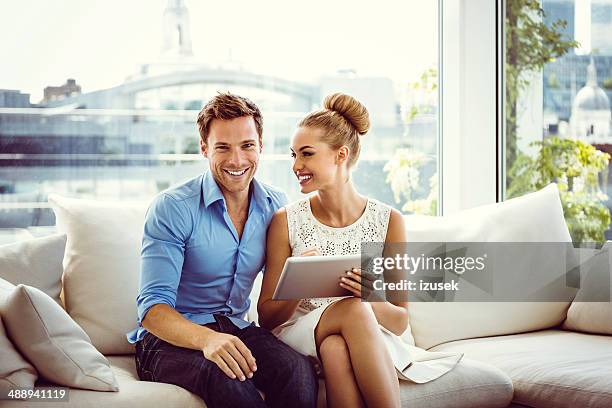 couple using a digital tablet - women of penthouse stock pictures, royalty-free photos & images