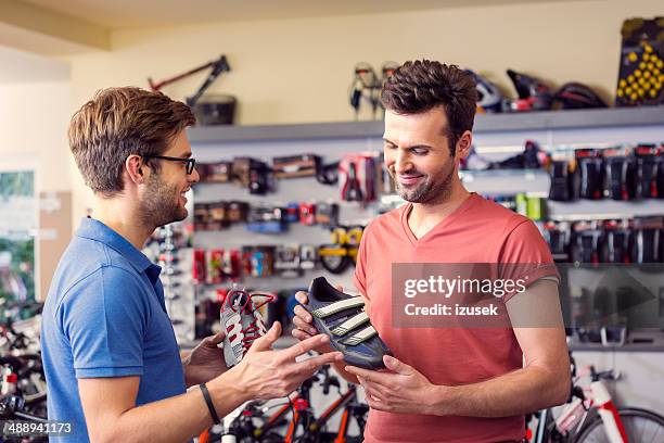 man buying cycling shoes - sports equipment store stock pictures, royalty-free photos & images