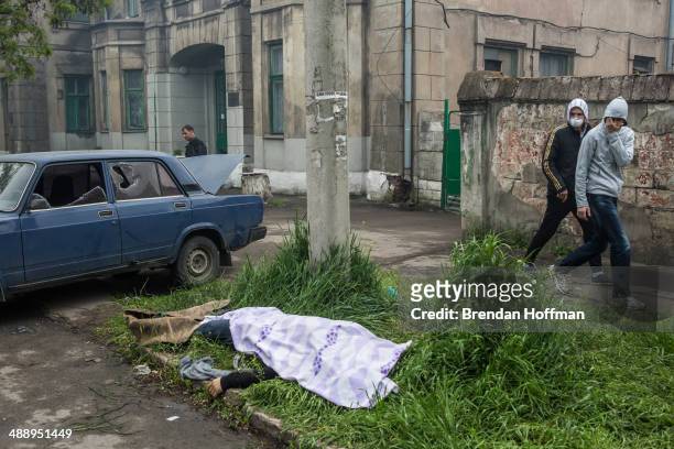 The body of a man killed in clashes lies along the street near a police station which was attacked and burned on May 9, 2014 in Mariupol, Ukraine....