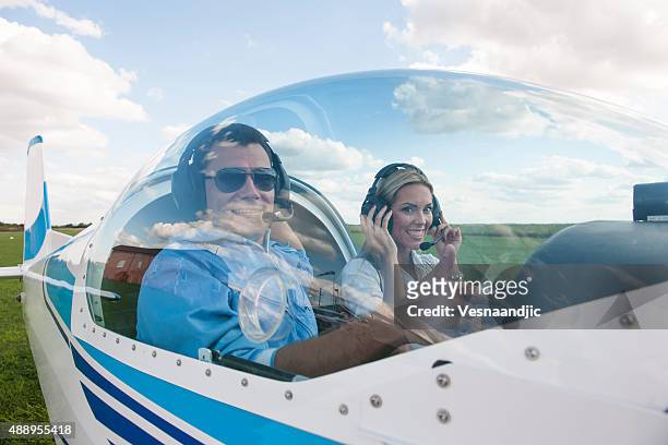 woman and man pilot looking at camera, preparing for flying - small airplane stock pictures, royalty-free photos & images