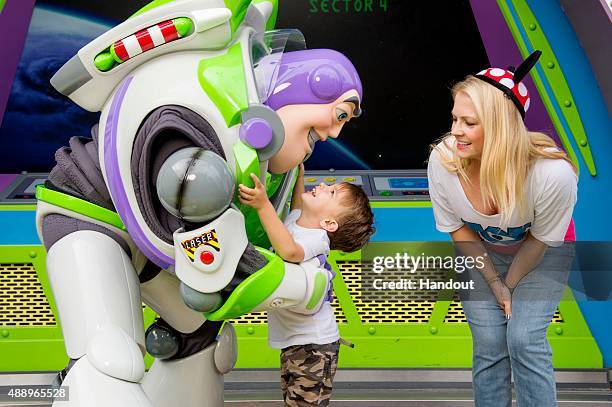 In this handout photo provided by Disney Parks, actress Melissa Joan Hart looks on as her son Tucker greets Buzz Lightyear at Magic Kingdom park on...