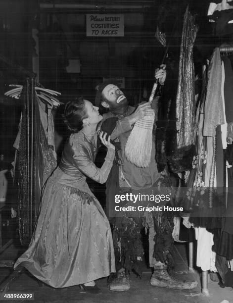 Circus performer Emmett Kelly wearing his 'Weary Willie' clown costume, with actress Maria Hart, in the costume department of the Pasadena Playhouse,...