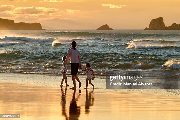family walking along the beach in spain - cantabria stock pictures, royalty-free photos & images