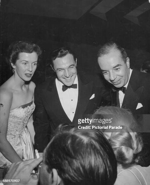 Actor and dancer Gene Kelly, with his wife Betsy Blair and director Vincente Minnelli, attending a Hollywood Party, California, March 1953.