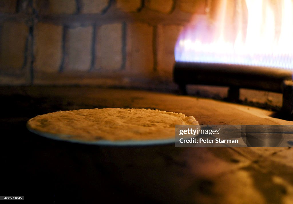 Pizza dough rising in brick oven