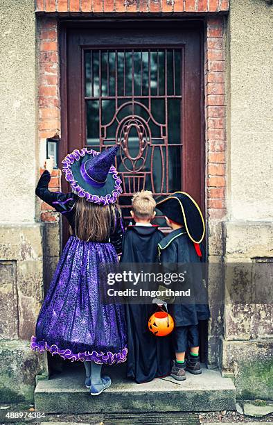 halloween kids ringing the doorbell of an old scary house - girl doorbell stockfoto's en -beelden