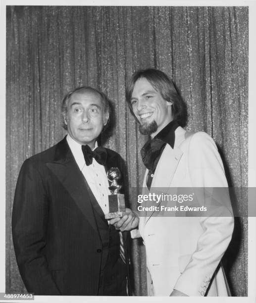 Composer Henry Mancini and actor Keith Carradine at the 33rd Golden Globe Awards, with the latter holding his award for Best Original Song,...