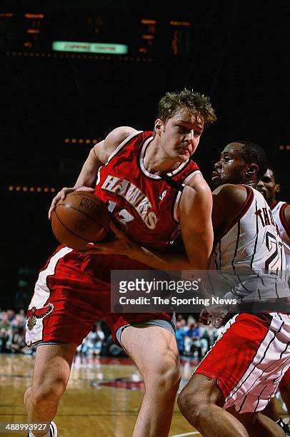 Hanno Mottola of the Atlanta Hawks moves around Kenny Thomas of the Houston Rockets during the game on April 7, 2001 at Compaq Center in Houston,...