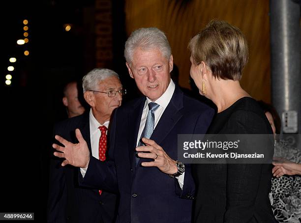 Former U.S. President Bill Clinton speaks with Joanne Heyler, founding director of The Broad, as they walk to a dinner with Eli Broad, founder of The...