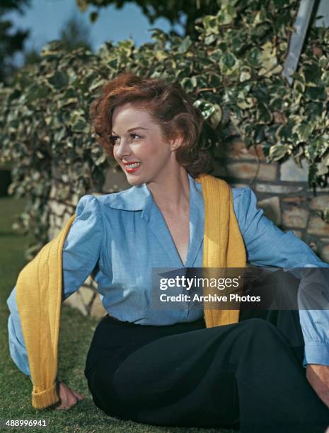 American actress Susan Hayward with a yellow sweater draped around her shoulders, circa 1949.