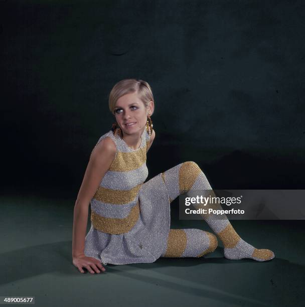 English fashion model Twiggy wears a knitted silver and gold striped sweater, skirt and matching lurex style stockings in 1967.