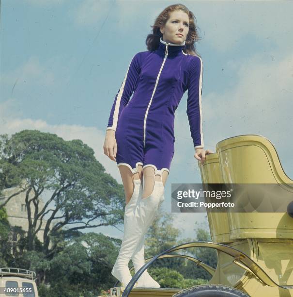 English actress Diana Rigg posed on a vintage car on location during filming of the television series 'The Avengers' at Beaulieu, Hampshire in...