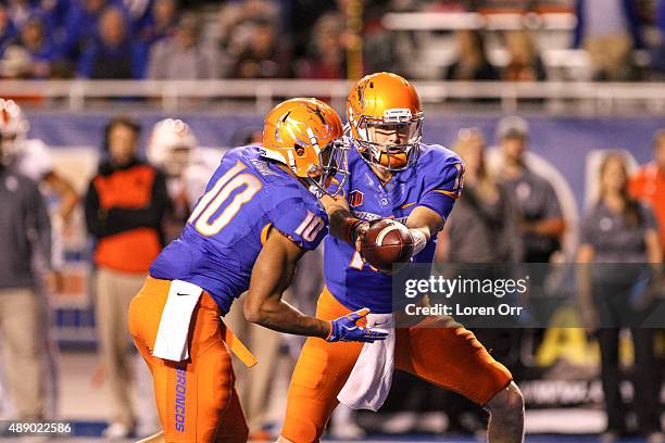 Quarterback Alex Ogle of the Boise State Broncos hands off to running back Cory Young during second half action against the Idaho State Bengals on...