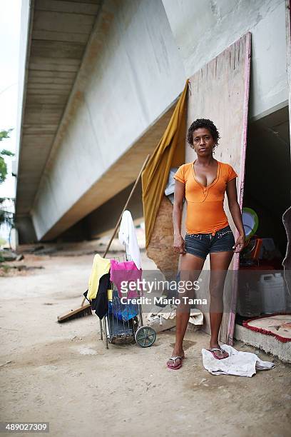 Viviane Sabino de Souza poses in front of her makeshift dwelling beneath a stretch of the Transcarioca BRT highway being constructed on May 9, 2014...