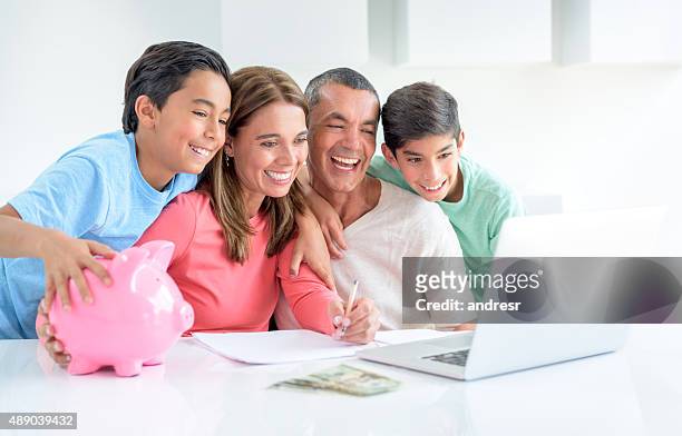 family saving money in a piggybank - couple saving piggy bank stock pictures, royalty-free photos & images