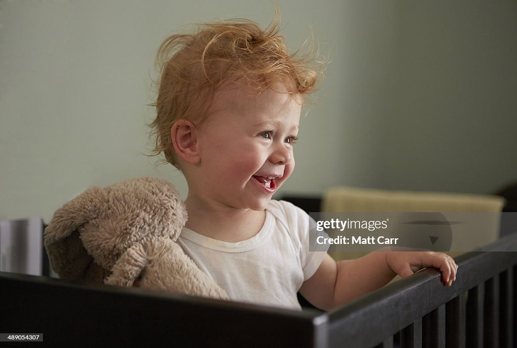 Young girl smiling in crib