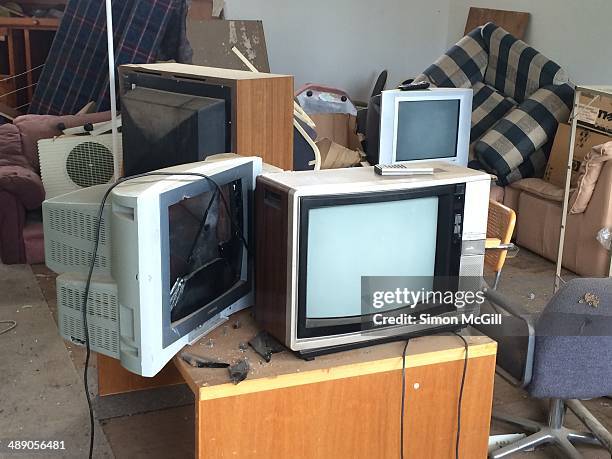 Dusty & obsolete cathode ray tube televisions in messy storage room