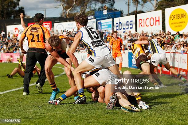 The emergency umpire gets involved as players from both teams wrestle during the VFL Preliminary Final match between Box Hill Hawks and Sandringham...